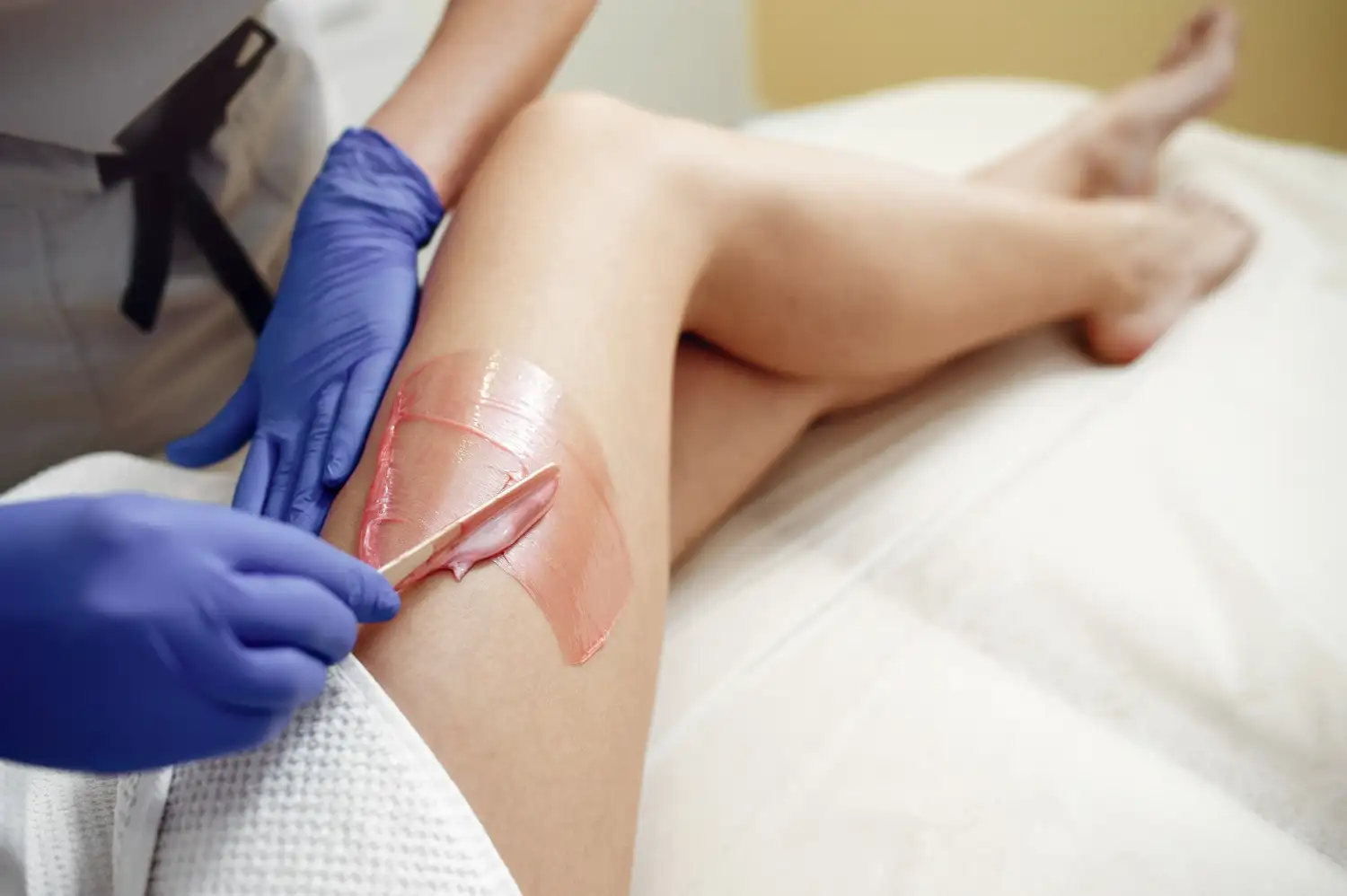 Beauty technician providing brow waxing service in a stylish salon, highlighting the grooming process