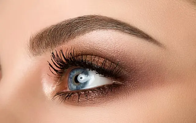 Close-up of a professional performing eyebrow threading on a client in a modern New York City salon, highlighting precision and technique
